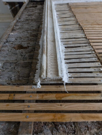 Close-up of a newly installed timber lath wall at the Arding and Hobbs building in London, prepared for traditional lime plaster application. The image highlights material contrasts on site, illustrating the integration of new heritage-appropriate substrates alongside retained historic fabric. Ideal reference for architects focused on compatible materials and breathable construction in conservation projects.